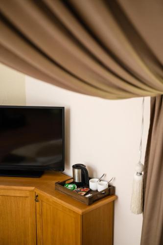 a room with a television and a table with cups at Bogolvar Retreat Resort in Antonovka