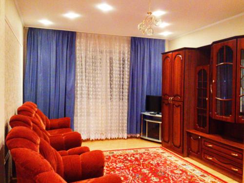 クルスクにあるApartment Na 50 Let Oktyabryaのリビングルーム(ソファ、青いカーテン付)