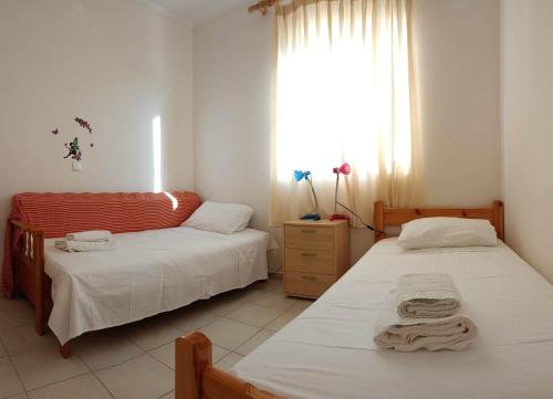 1 Schlafzimmer mit 2 Betten und einem Fenster in der Unterkunft Ukulele central apartment in Sami