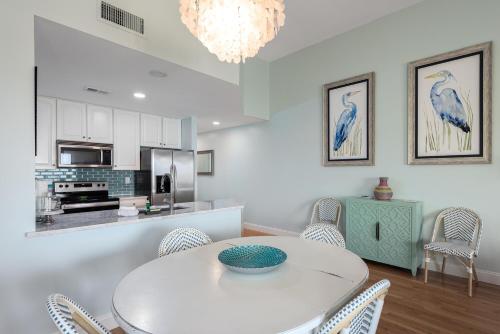 Un comedor con una mesa y sillas blancas. en 13108 Pelican Watch Villa, en Seabrook Island