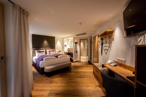 a bedroom with a bed and a desk in it at Hotel Zum Ochsen in Schonwald im Schwarzwald