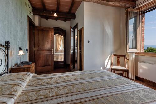 a bedroom with a large bed and a window at Locanda Poggioleone in Castiglione del Lago