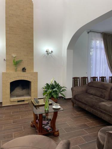a living room with a couch and a fireplace at Гостевой Дом Феникс in Sukhum