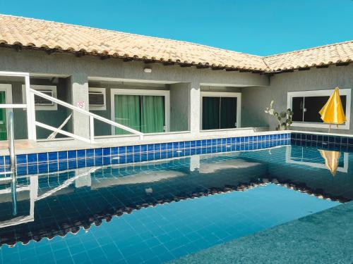 a swimming pool in front of a house at Pousada São Pedro in São Pedro da Aldeia