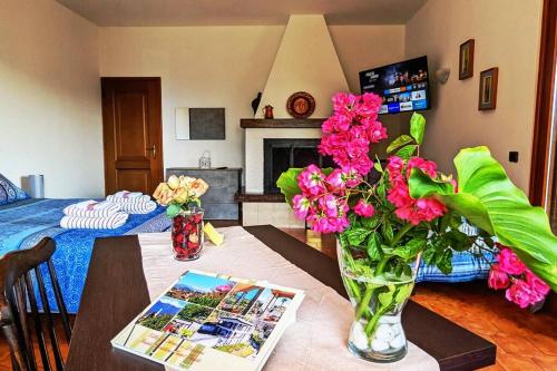 un soggiorno con tavolo e vaso di fiori di Villa Le Arcate zona Lago Maggiore a Cittiglio