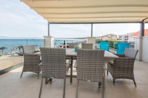 a table and chairs on a patio with a view of the ocean at Apartmani Podoreški in Vir