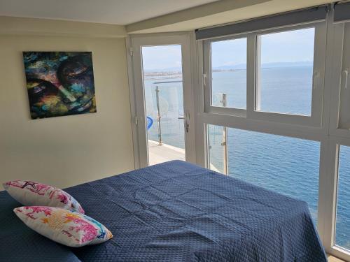 a bedroom with a bed and a view of the ocean at Casa del Mar in Almería