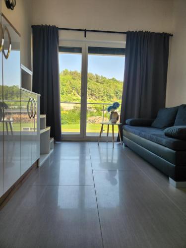 a living room with a couch and a large window at Aaki Apartment Diegten in Diegten