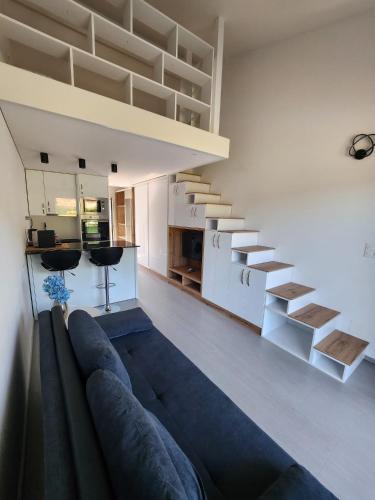 a living room with a couch and a staircase at Aaki Apartment Diegten in Diegten