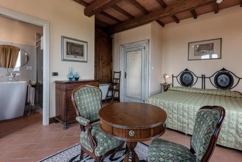 a bedroom with a bed and a table and chairs at Locanda Poggioleone in Castiglione del Lago