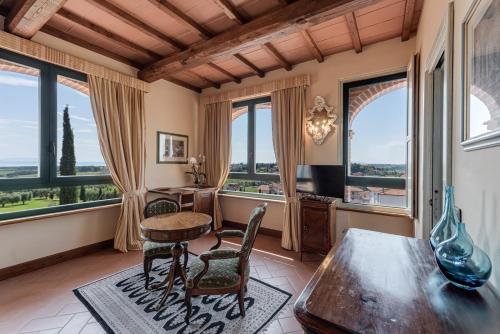 a home office with a desk and chairs and windows at Locanda Poggioleone in Castiglione del Lago