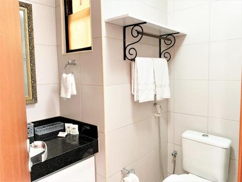 een badkamer met een wit toilet en een wastafel bij Edifício Setai Apto 413 ER Hospedagens in Maceió