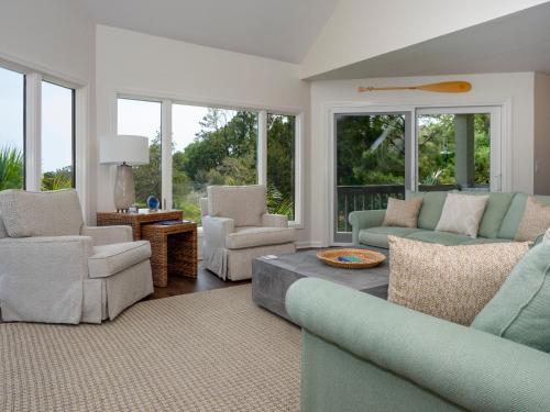 a living room with a couch and chairs and windows at 1515 Deer Pointe Villa in Seabrook Island