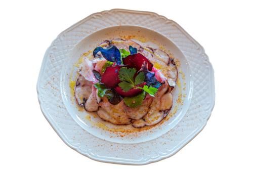 a white plate with a bowl of food with strawberries at Locanda Poggioleone in Castiglione del Lago