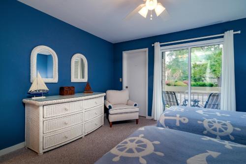 a blue bedroom with a bed and a dresser and a chair at 1807 Heron Pt in Seabrook Island