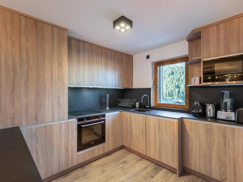 une cuisine avec des armoires en bois et une fenêtre dans l'établissement Appartement 4* au centre de Courchevel Moriond, 4 chambres, 98m², 10 pers, parking, WIFI - FR-1-563-79, à Courchevel