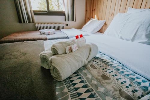 una camera d'albergo con due letti con asciugamani sopra di Pousada Casa da Paz a Gramado