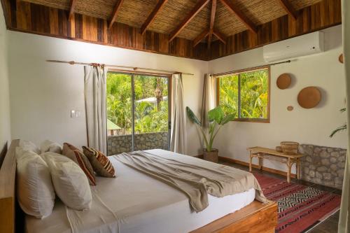 - une chambre avec un grand lit et une fenêtre dans l'établissement Dream Surf House Avellana, à Playa Avellana