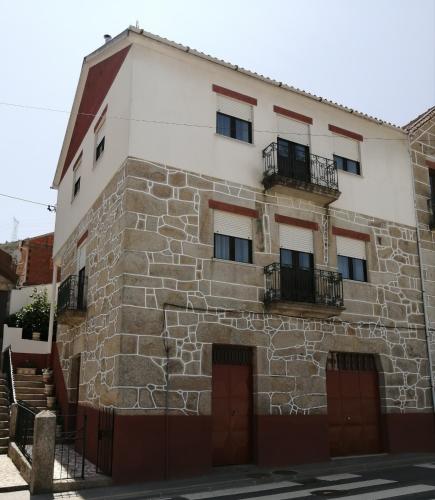 an old stone building with two doors and two balcony at Casa do César Douro Guest House in Tabuaço