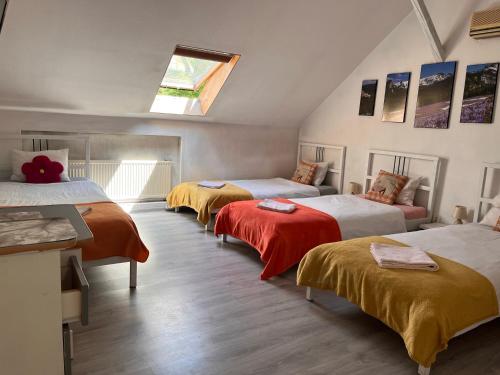オシフィエンチムにあるホワイト ガーデンのベッド4台(オレンジ&白のシーツ付)が備わる客室です。