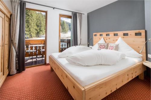 een slaapkamer met een groot bed met witte kussens bij Sunneschlössli Tannheimer Tal in Nesselwängle