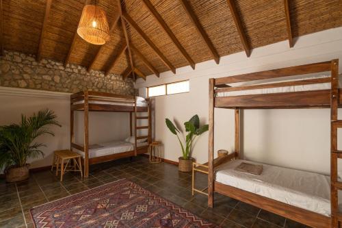 a room with two bunk beds and a rug at Dream Surf House Avellana in Playa Avellana