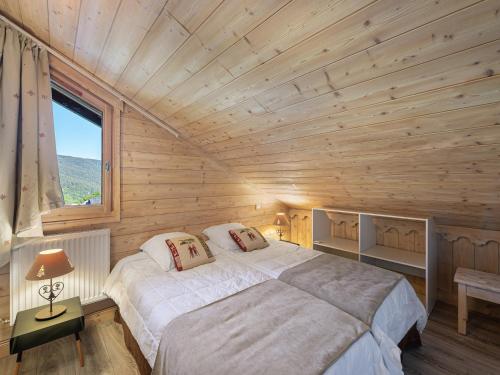Cette chambre en bois comprend un grand lit. dans l'établissement Duplex lumineux à Méribel Village : skis aux pieds, piscine et spa inclus - FR-1-566-48, à Les Allues
