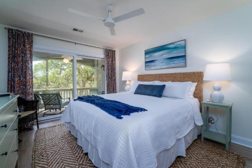 1 dormitorio con 1 cama grande y balcón en 2123 Bay Pointe Villa, en Seabrook Island