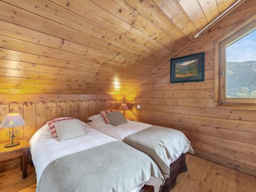une chambre avec deux lits dans une cabane en rondins dans l'établissement Duplex lumineux avec terrasse, piscine et spa à Méribel, accès direct aux pistes - FR-1-566-49, à Les Allues
