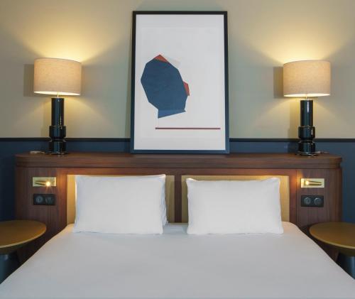 a bedroom with two beds and two lamps at voco Paris - Porte de Clichy by IHG in Clichy