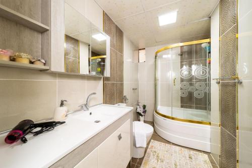a bathroom with a shower and a sink and a toilet at Apartment with Panoramic City View in Kepez in Antalya