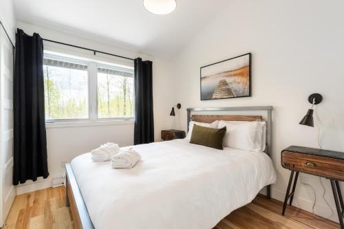 En eller flere senge i et værelse på Le Memph Hirondelle spacious comfortable condo cottage eco responsible 3 bedrooms - hot tub & pool Memphrémagog Lake