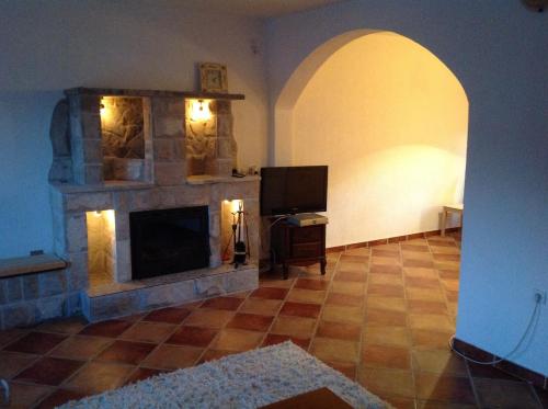 a living room with a fireplace and a television at Guest House "Paradise" in Tivat