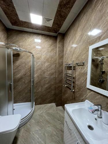 een badkamer met een douche, een wastafel en een spiegel bij Aylin Boutique Hotel in Gabala