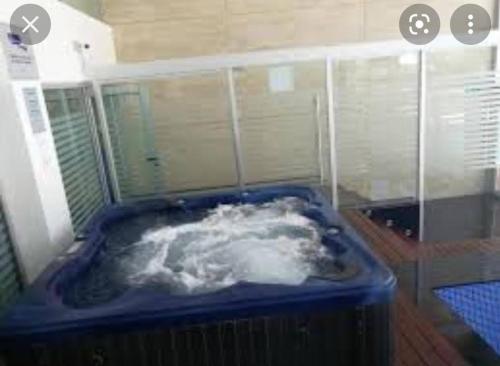 El baño incluye una bañera azul llena de nieve. en Diamantis Apartamento de Lujo y Confort en Montevideo