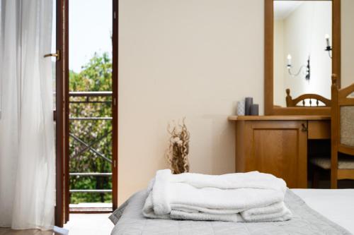 a stack of towels sitting on a bed in front of a mirror at Bogolvar Retreat Resort in Antonovka