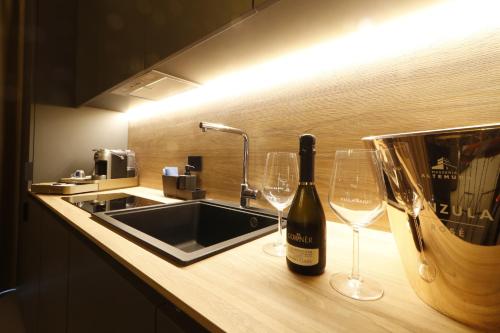 a bottle of wine sitting on a counter with wine glasses at Giargeri Home in Misterbianco