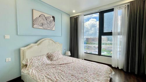 a bedroom with a bed and a large window at LAD Apartment & Homestay Hải Phòng - Hoàng Huy Grand Tower in Hai Phong