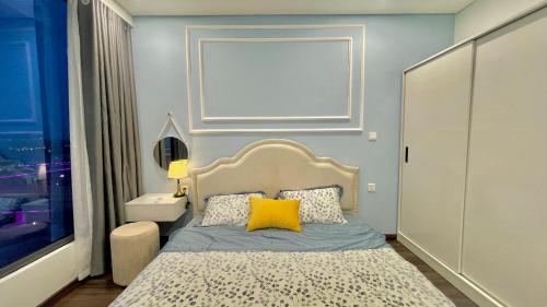 a bedroom with a bed with a yellow pillow on it at LAD Apartment & Homestay Hải Phòng - Hoàng Huy Grand Tower in Hai Phong