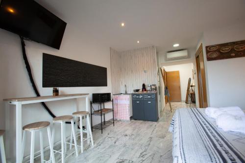 una camera con letto e una cucina con bar di Suites Beach Nature by Alterhome a Vélez-Málaga