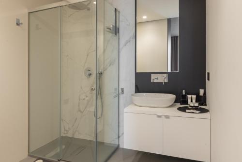 a bathroom with a glass shower and a sink at Giargeri Home in Misterbianco