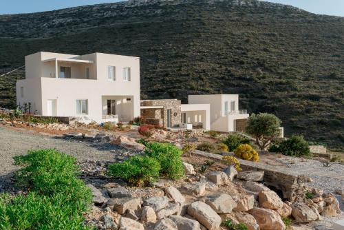 a house on top of a hill with rocks at Noble 7 Suites - Adults Only - Onar Hotels Collection in Parikia