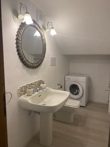 a bathroom with a sink and a washing machine at Smeralda in Cugnana