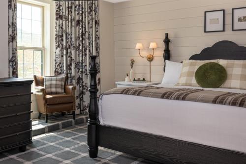 a bedroom with a bed and a chair and a window at The Wentworth in Jackson