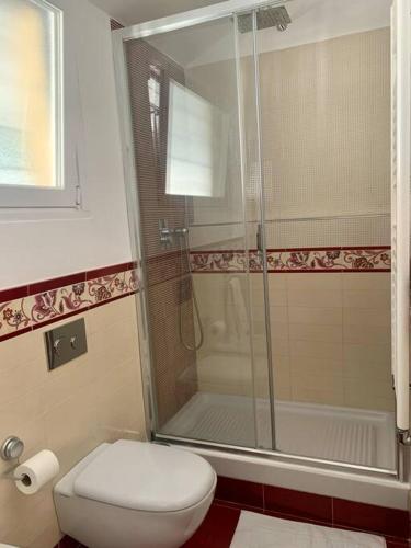 a bathroom with a toilet and a glass shower at Gassa d'Amante Appartamento in Rapallo