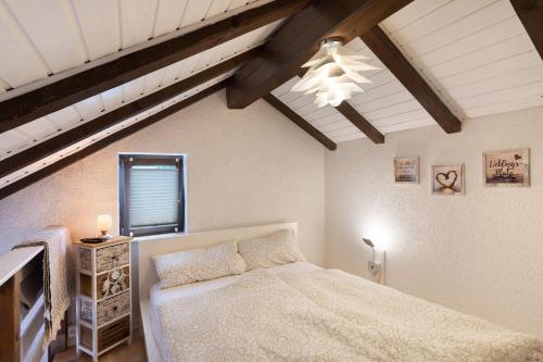 ein Schlafzimmer mit einem weißen Bett und einer Decke in der Unterkunft Ferienwohnung Schwarzwald Engel in Bad Peterstal-Griesbach