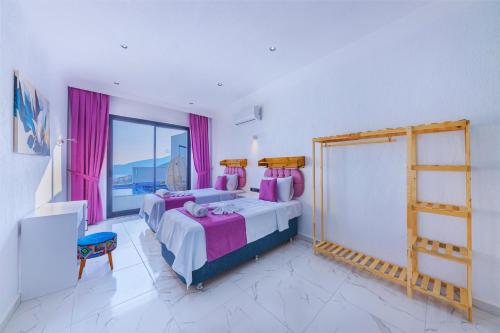 a bedroom with two beds and a window with pink curtains at Villa Arya in Kaş