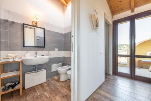 a bathroom with a sink and a toilet at La Casa di Francy in Villasimius