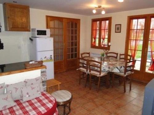 eine Küche und ein Esszimmer mit einem Tisch und Stühlen in der Unterkunft Le Pressoir in Cresseveuille