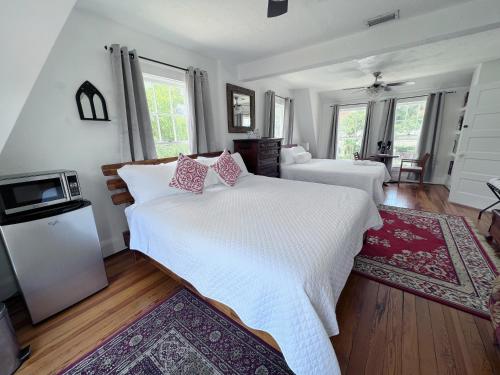 a bedroom with two beds with white sheets and red pillows at The Reserve Retreat in Sarasota
